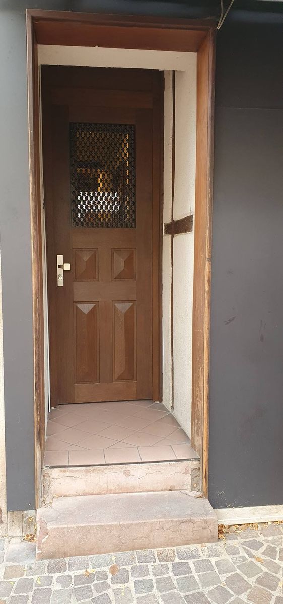 Nouvelle porte d'entrée en chêne au fond d'une entrée avec marches